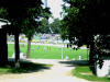 Blick durch den Zaun zum Spielfeld, im Hintergrund der G�steblock